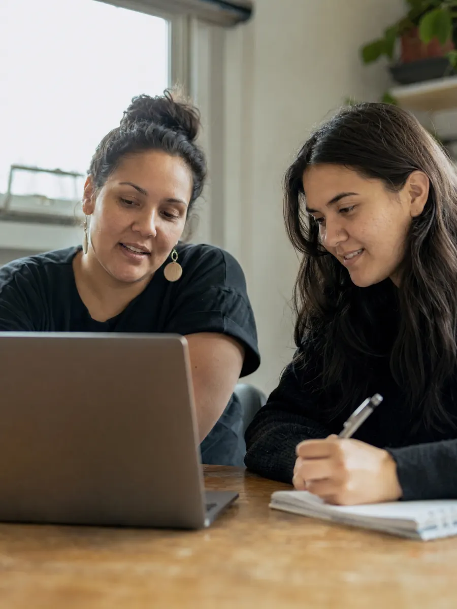 A staff member and a young woman planning together at a laptop